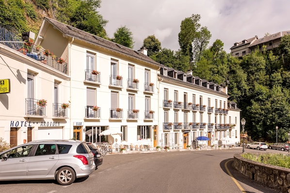A hotel with a bar, outdoor seating, and balconies with flower boxes. - Hôtel Ardiden (Luz-Saint-Sauveur)