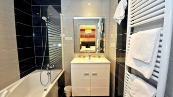 A modern bathroom with a bathtub, a vanity with a mirror, and a towel rack.