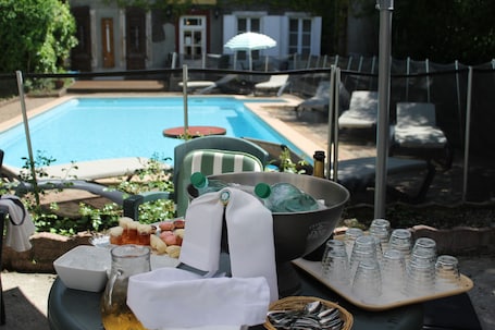 Una piscina al aire libre de temporada, sillones reclinables de piscina