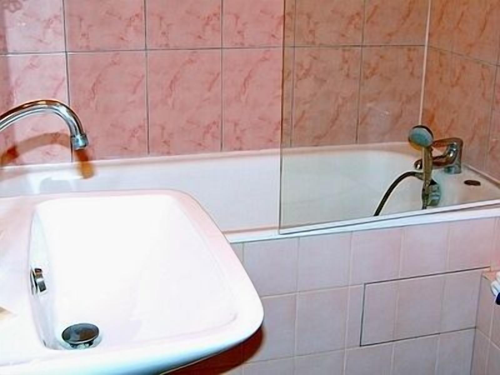 A bathroom with a white sink and a bathtub.