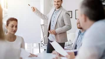 A professional meeting with a person presenting to a group.