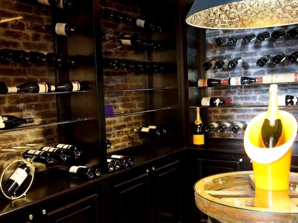 Bodega con estantes llenos de botellas de vino y un dispensador de vino.