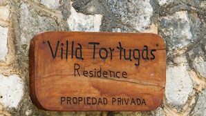 Uma placa de madeira com a inscrição 'Villa Tortugas Residence' e 'PROPIEDAD PRIVADA'.