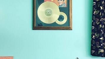 Portada de álbum de Elvis Presley enmarcada sobre una pared verde azulada.