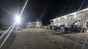Un motel de varios pisos con estacionamiento.