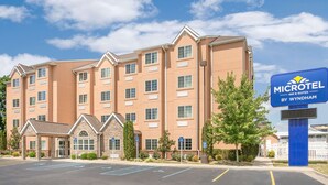 A Microtel Inn & Suites building with a parking lot and a sign indicating the hotel name.
