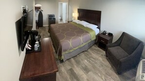 A hotel room with a bed, a desk, a chair, a TV, and a small table with a coffee maker. - Budget Lodge Eugene (Eugene)