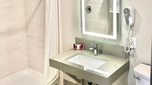A modern bathroom with a shower, a sink, a mirror, and a hairdryer. - Budget Lodge Eugene (Eugene)