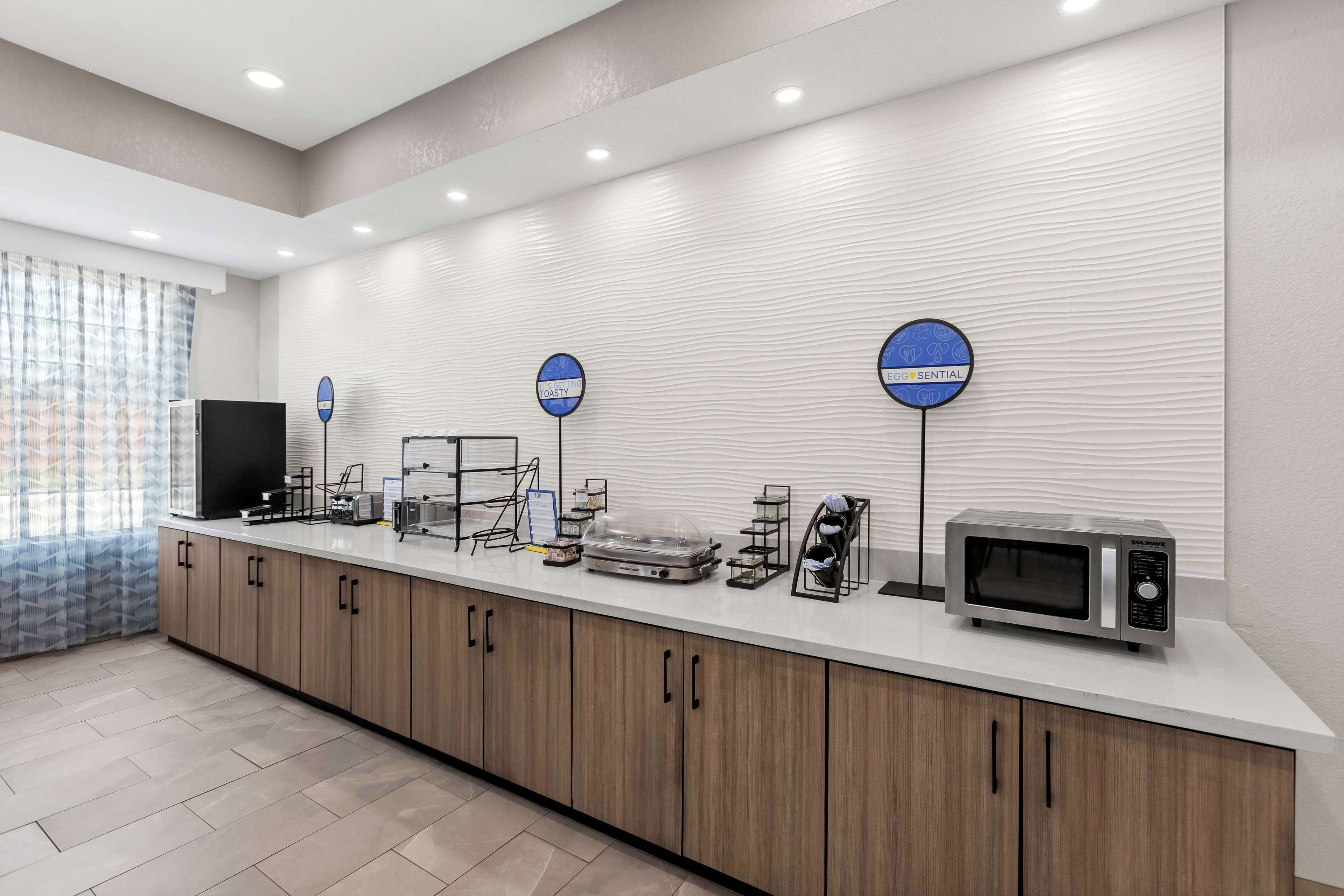 Una cocina moderna con microondas, tostadora y cafetera sobre la encimera.