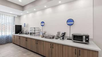 Una cocina moderna con microondas, tostadora y cafetera sobre la encimera.