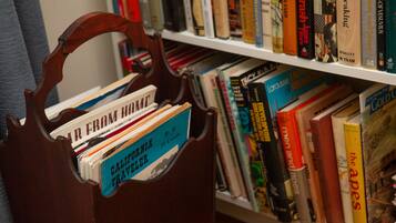 A wooden bookcase with a variety of books, including travel literature.