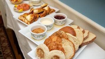 Un bufé de desayuno con diversos pasteles, frutas y mermeladas.