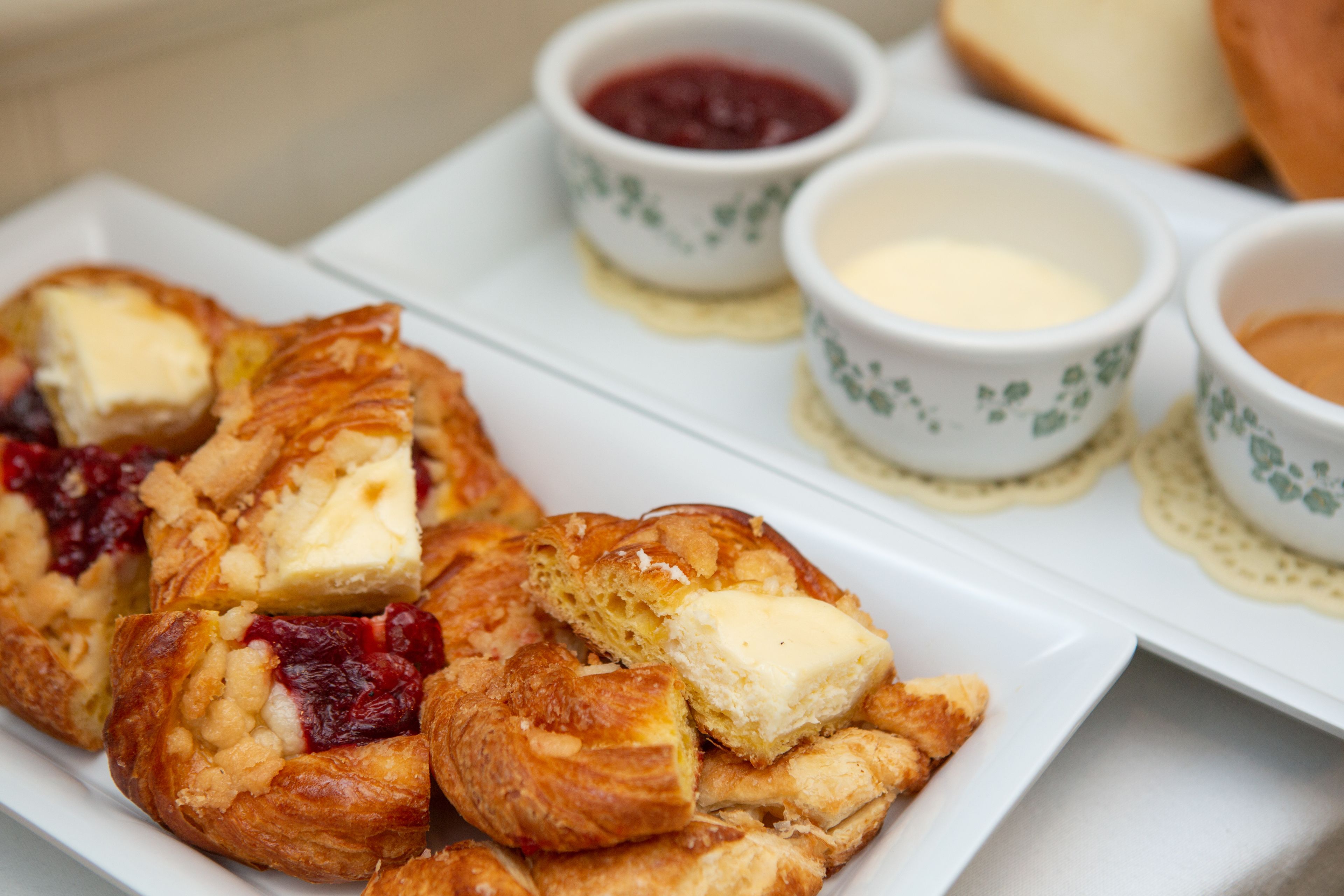 A plate of pastries with butter and jam.