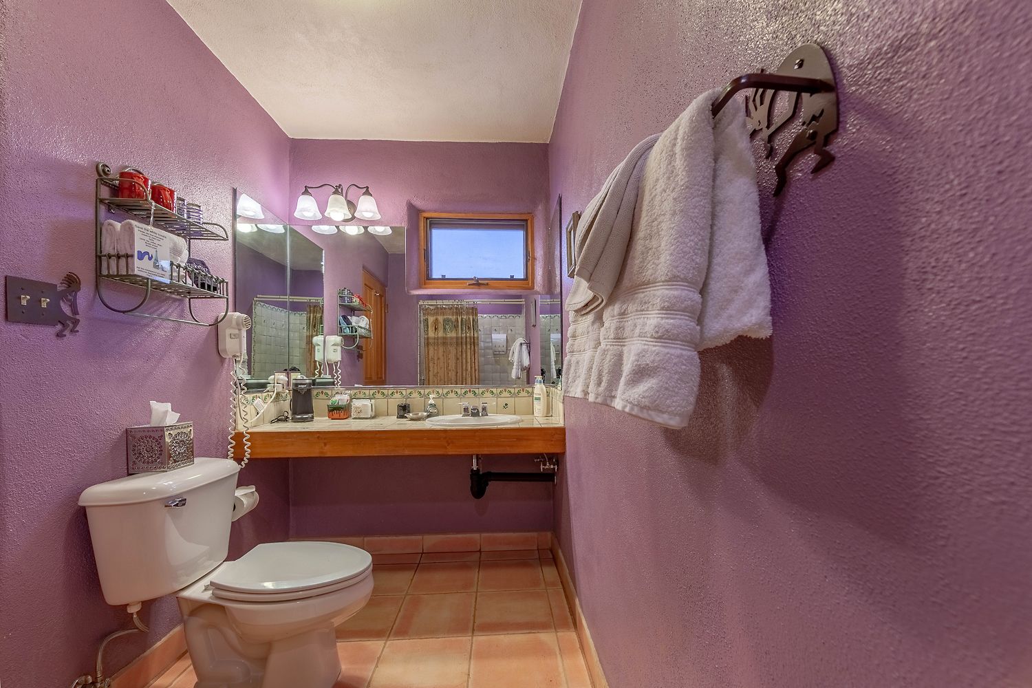 A compact bathroom with a toilet, sink, and a towel rack.