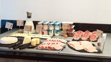 A cheese and deli counter with various cheeses, meats, and dairy products.