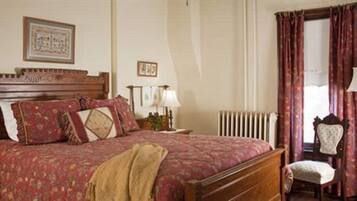 Un dormitorio con cama de madera, una silla, un radiador y cortinas.