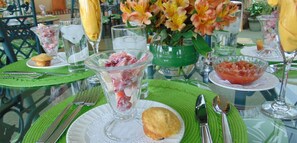Ein Tisch mit einer Dessertschale aus Glas, einem Muffin und einem Glas Wasser.