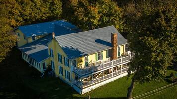 A large, two-story house with a blue roof and a wrap-around porch.