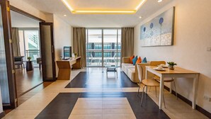 Una habitación de hotel moderna con un ventanal grande, un comedor y una sala de estar.
