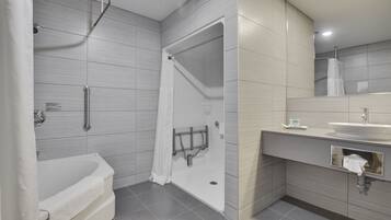 A modern bathroom with a walk-in shower, a bathtub, and a vanity with a sink and mirror.
