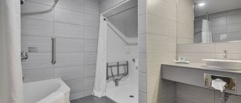 A modern bathroom with a walk-in shower, a bathtub, and a vanity with a sink and mirror.