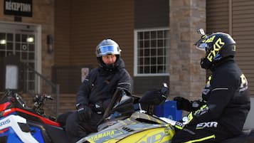 Deux personnes sur des motoneiges devant un bâtiment sur lequel on peut lire l’inscription « Réception ».