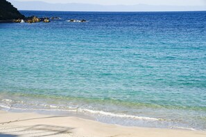 A beach with clear turquoise water and a sandy shore. - Tanegashima Araki Hotel (Nishinoomote)