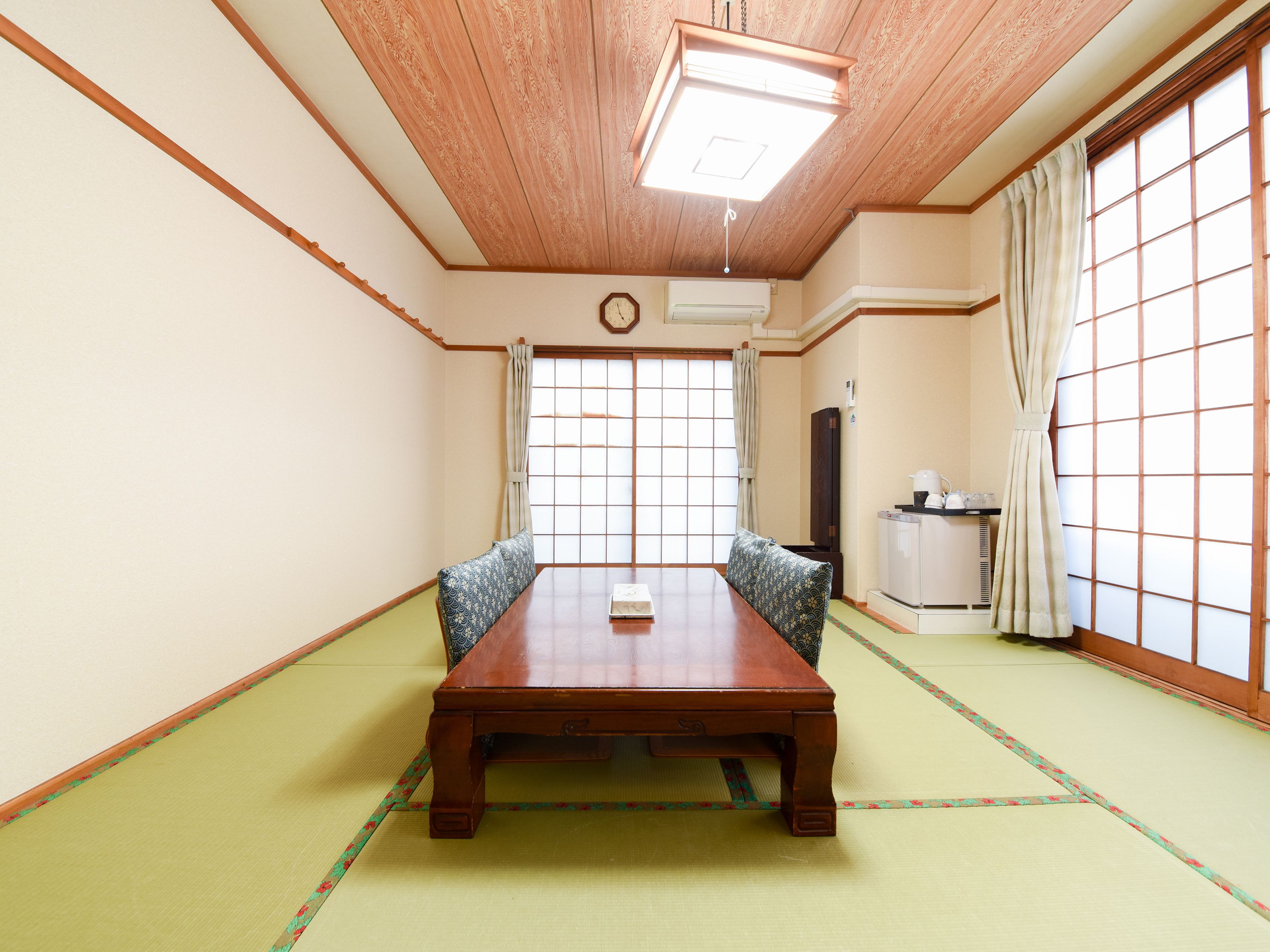 A traditional Japanese room with tatami flooring, a wooden table, and shoji screens.