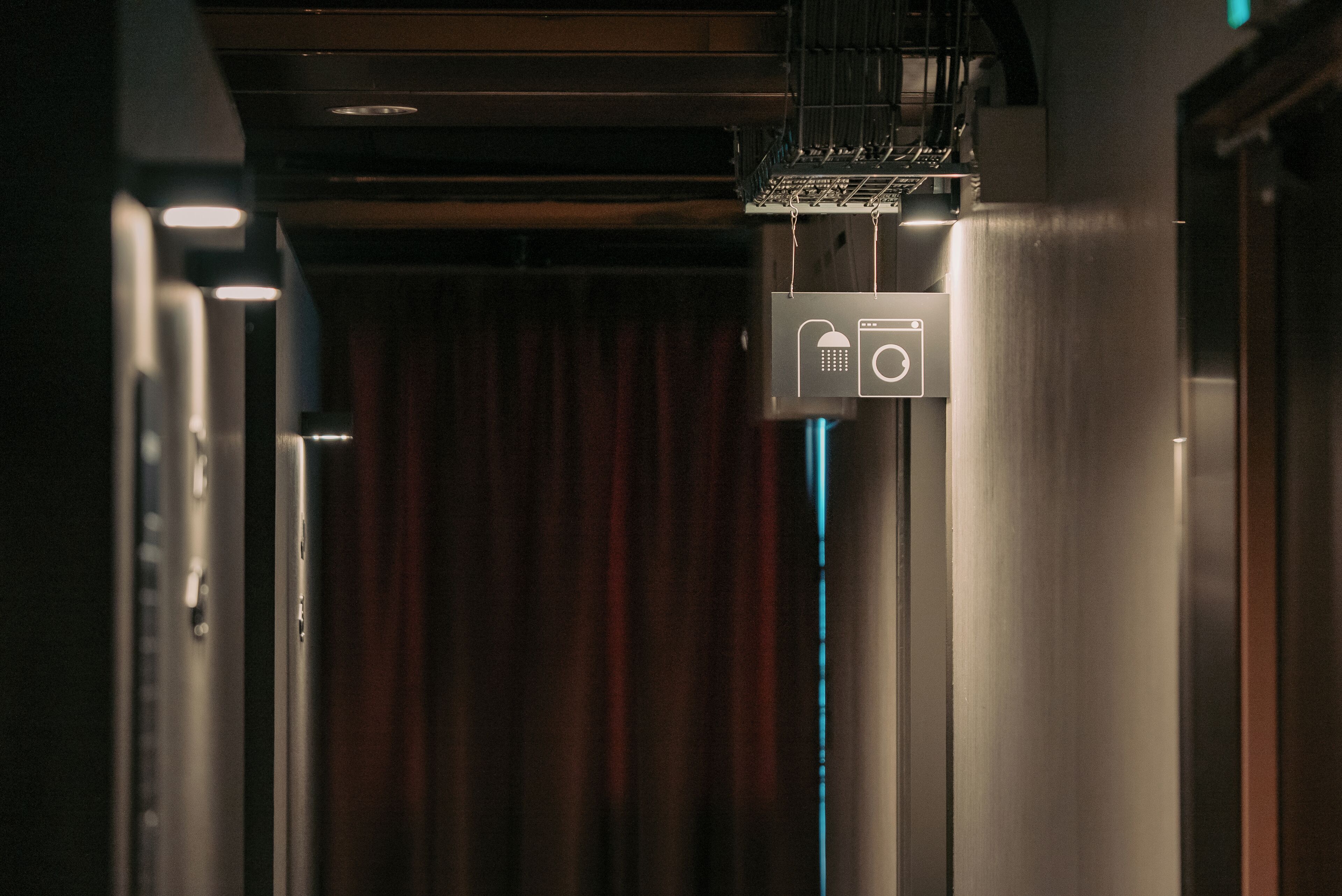 A hallway with a sign indicating a room with a shower.