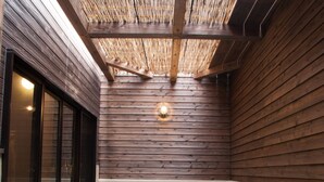 Un jacuzzi con techo de madera y piso de baldosas de piedra.