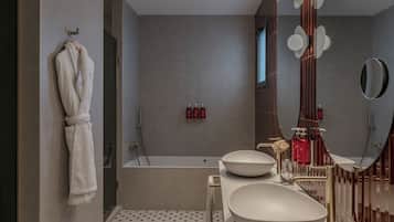 Un baño moderno con una bañera grande, dos lavamanos y un espejo.