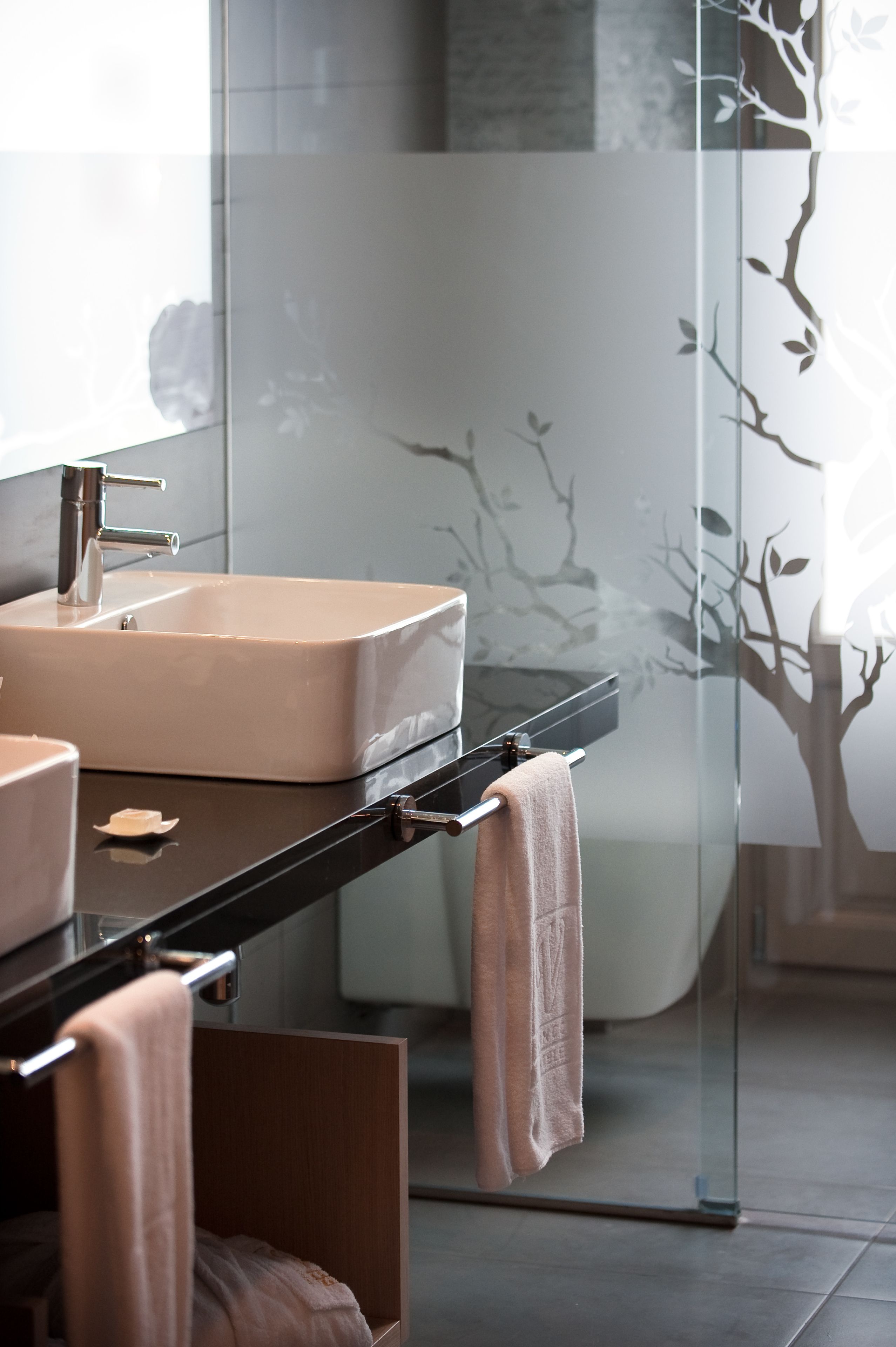Un baño moderno con un lavabo rectangular, un espejo y una cabina de ducha de vidrio.