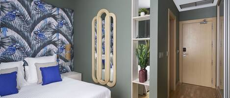 Un dormitorio con cama, un espejo grande, un armario y una planta.