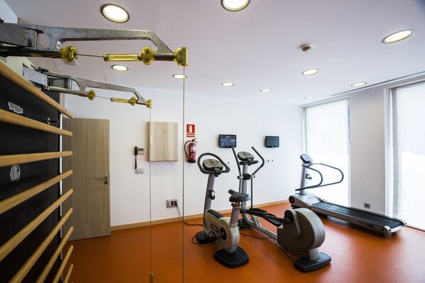 A gym with exercise equipment, a wooden rack, and a fire extinguisher.