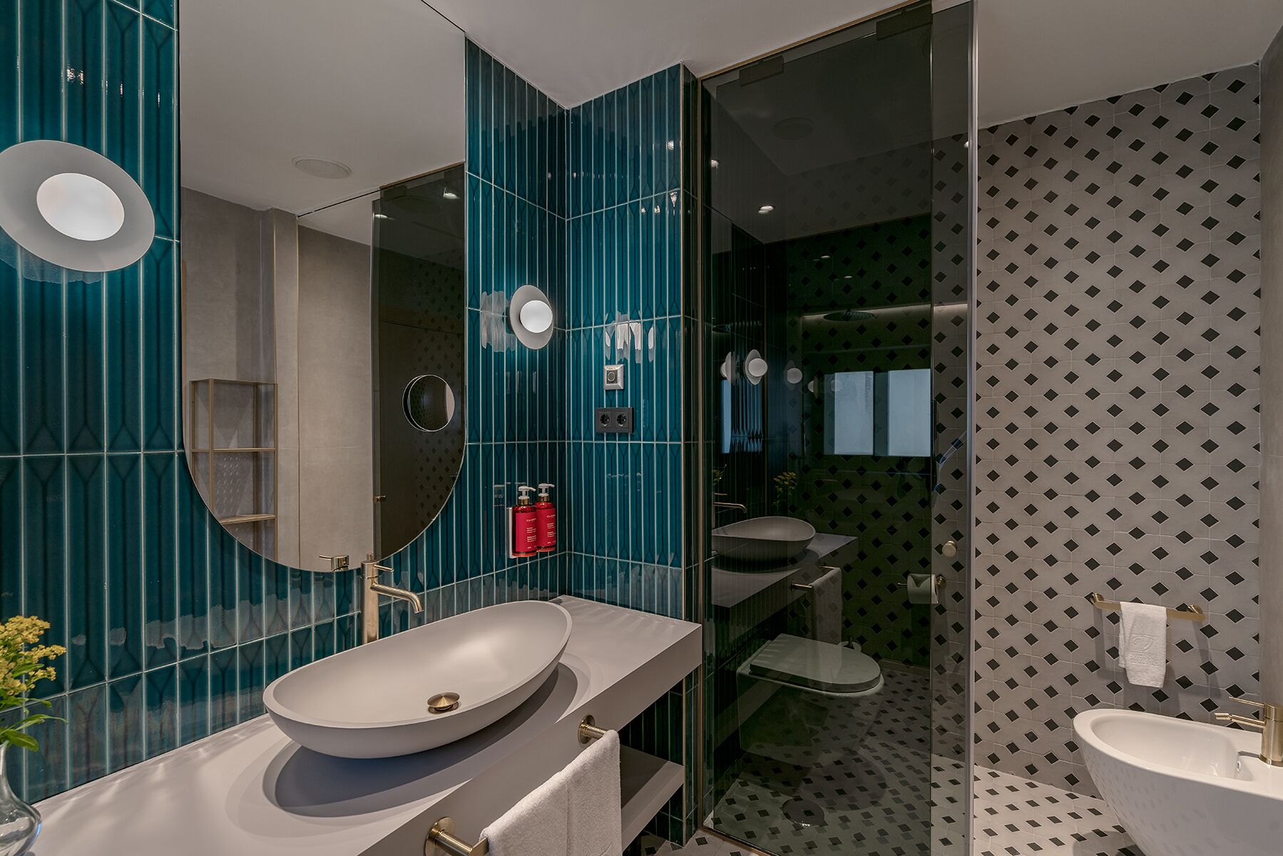 A modern bathroom with a large oval sink, a glass-enclosed shower, and a mirror.
