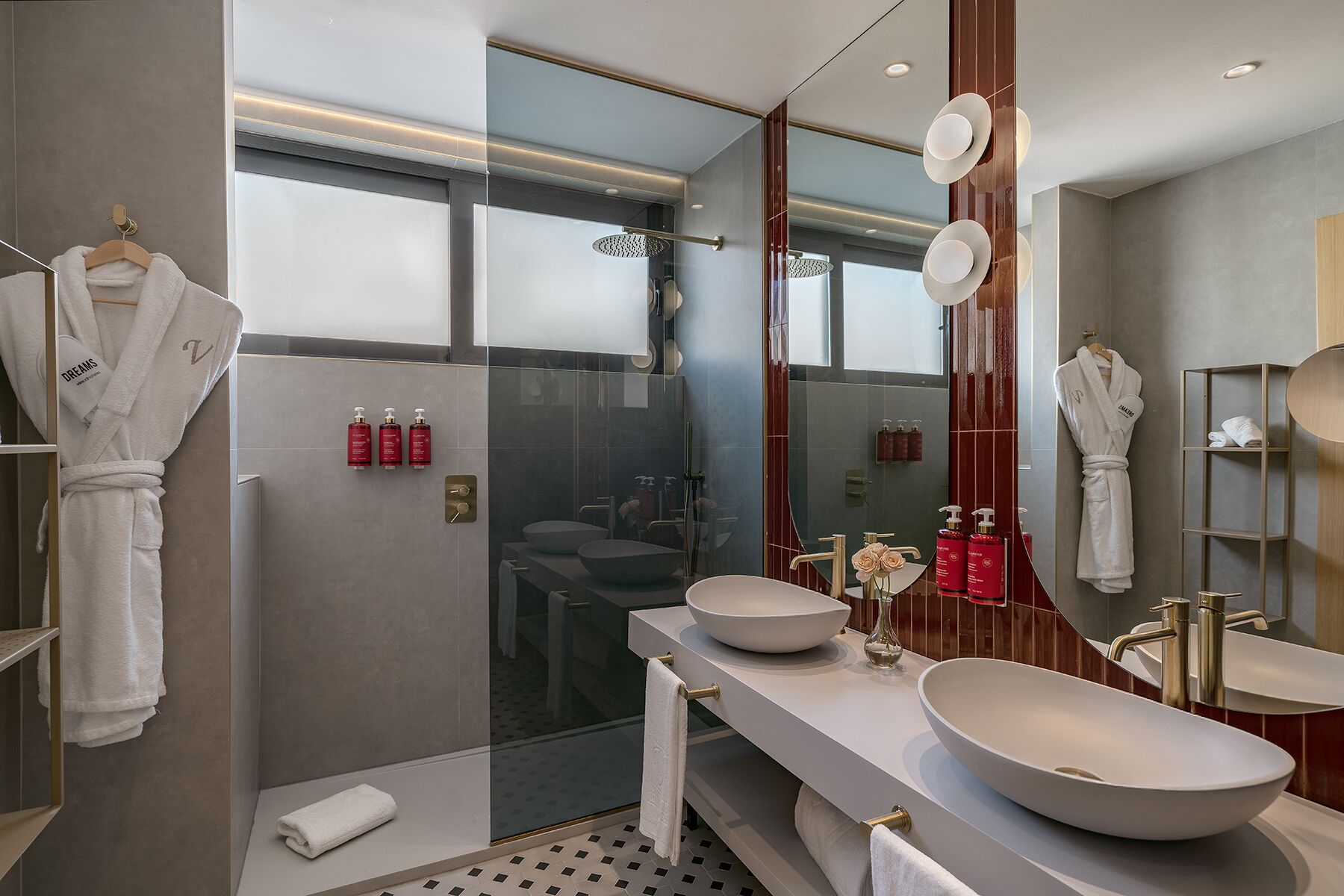 A modern bathroom with a glass-enclosed shower, two sinks, and a large mirror.