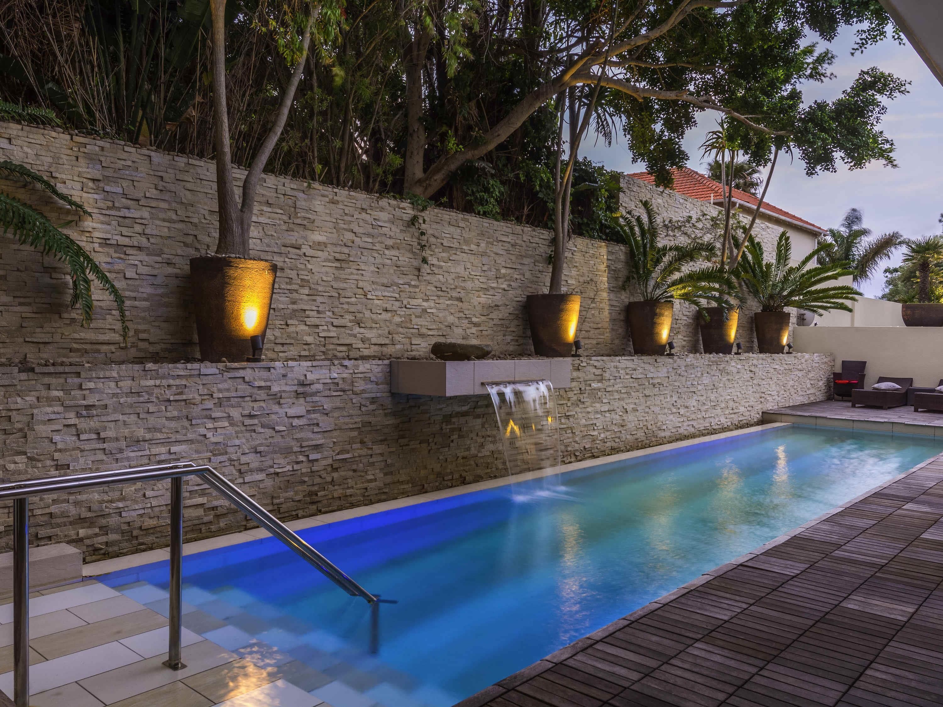 Una piscina al aire libre, sillones reclinables de piscina