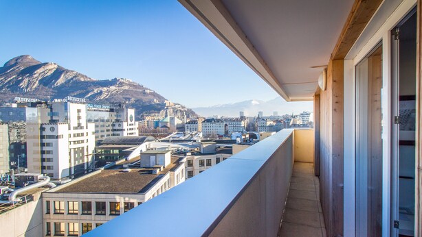 A balcony with a view of a cityscape, including buildings and a mountain. - Aparthotel Adagio Grenoble Centre (Grenoble)