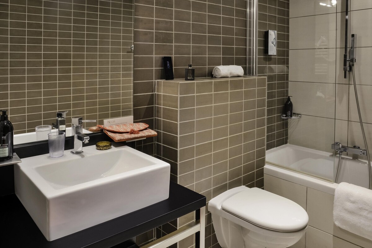 Une salle de bain avec un lavabo blanc, des toilettes et un espace douche.