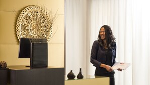 A reception desk with a decorative wall piece, a vase, and a monitor. - Aparthotel Adagio Grenoble Centre (Grenoble)