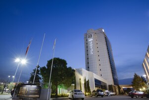 Un edificio de hotel alto con un diseño moderno, que presenta un letrero llamativo de 'hotel' en la fachada.