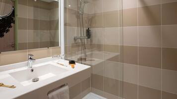 A bathroom with a shower, a sink, and a mirror.