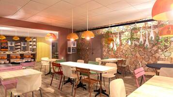 A restaurant interior with multiple tables and chairs, pendant lighting, and a patterned wall.