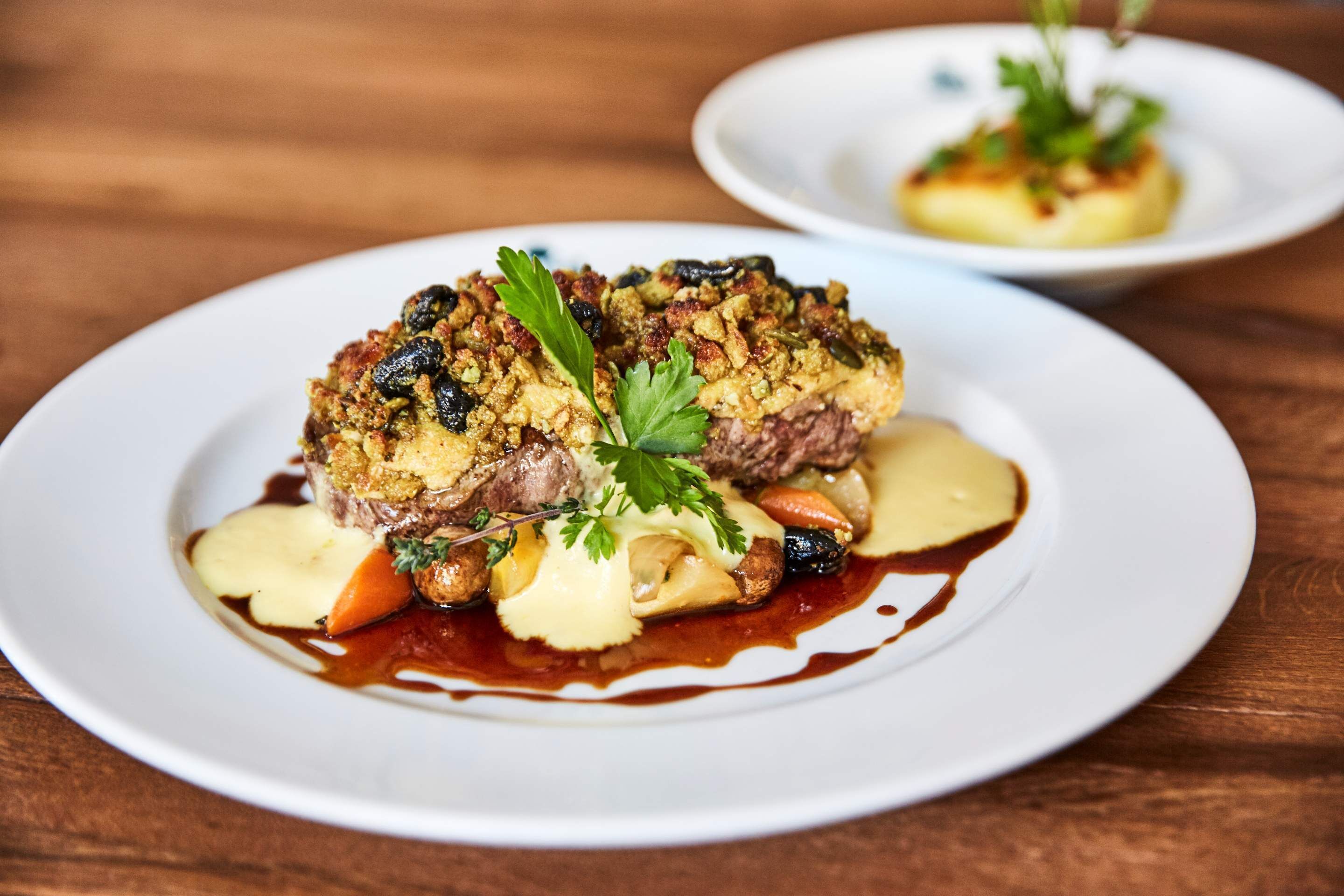A plated dish with meat, vegetables, and sauce.