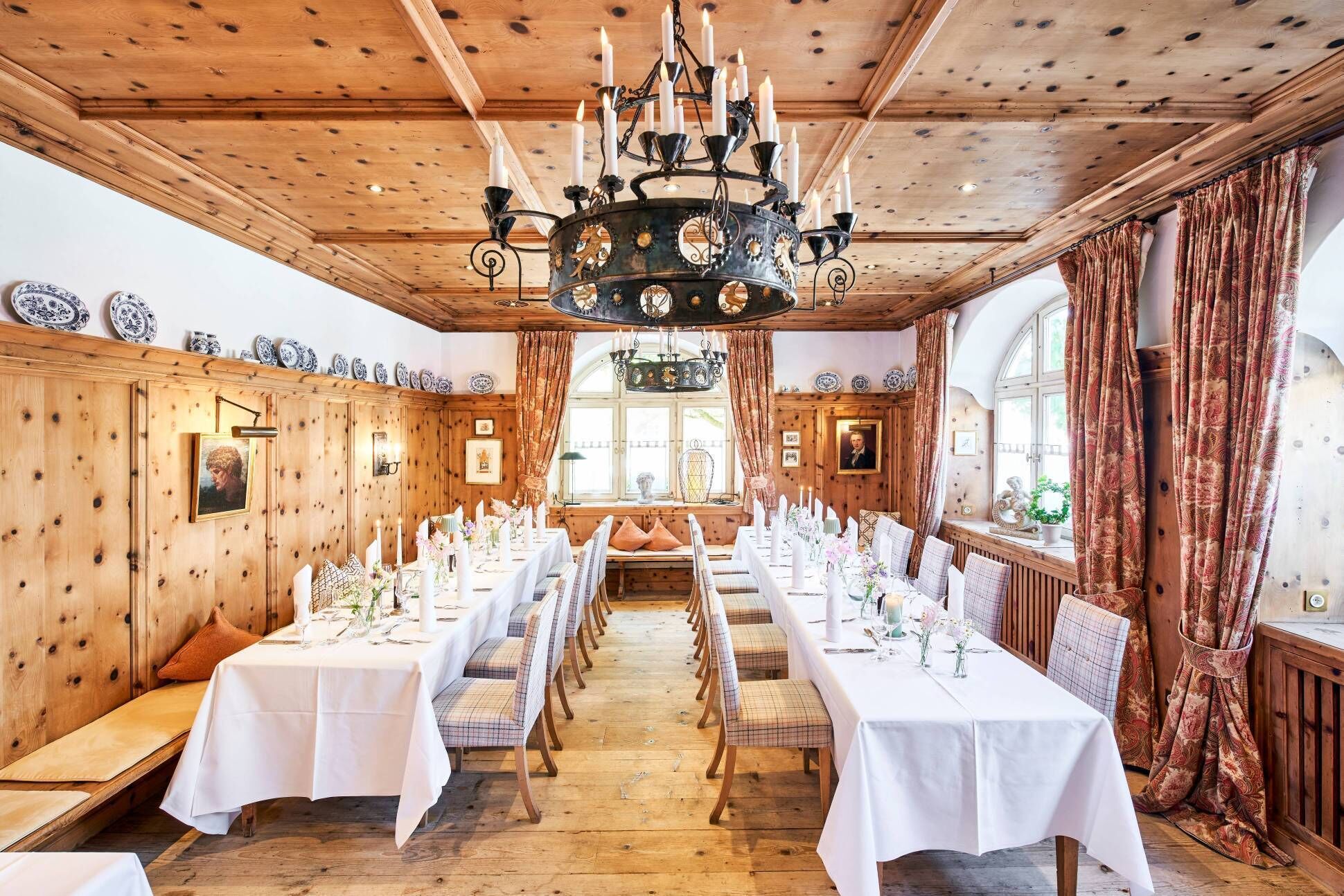 Ein langer Esstisch ist für eine Mahlzeit in einem Raum mit Holzwänden und einer Kristallleuchter gedeckt.
