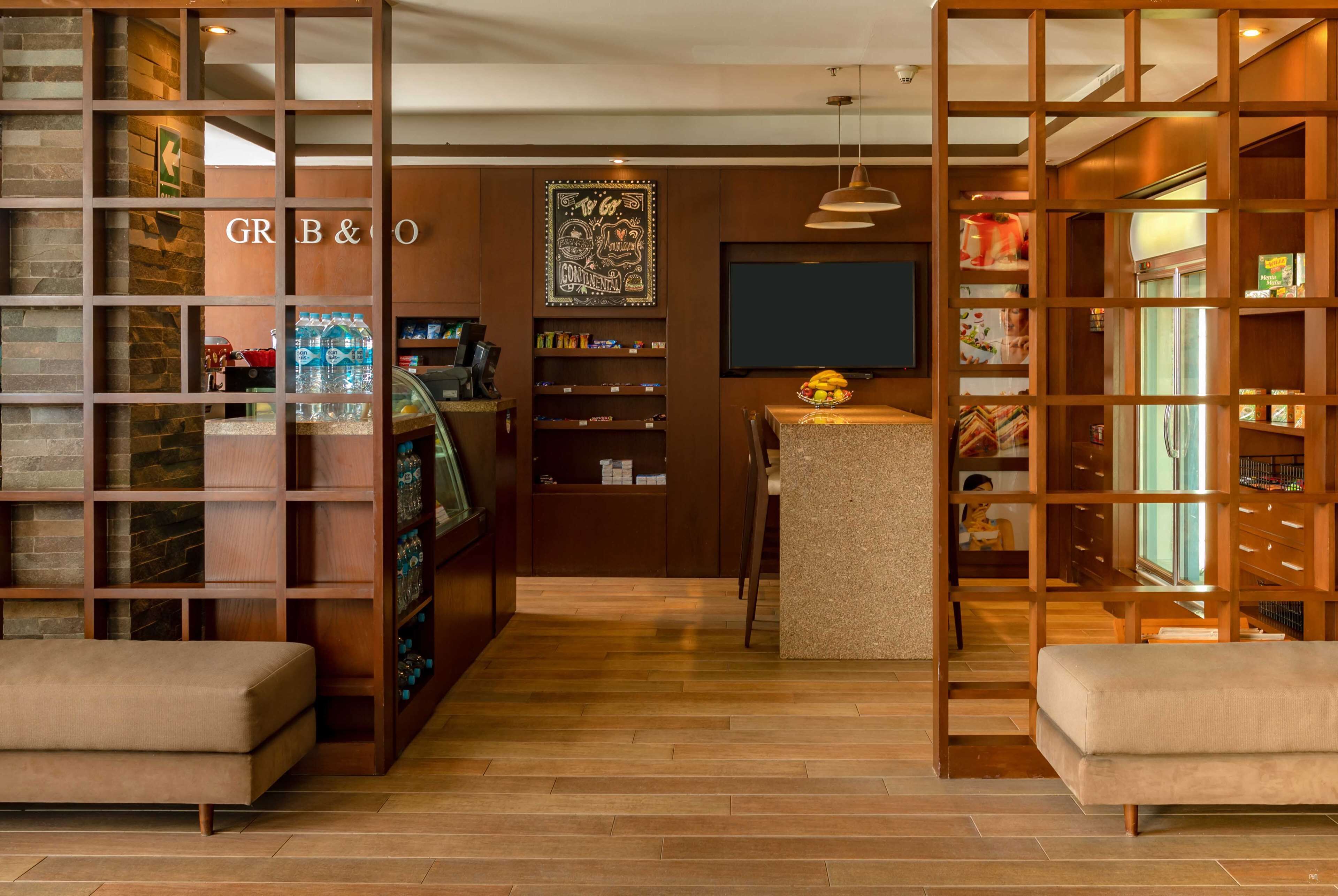 Un interior moderno con una recepción, estanterías de madera y un área de descanso.
