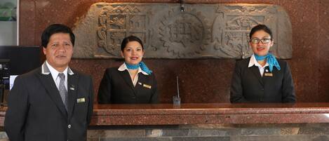 A reception desk with a stone wall and a carved emblem.