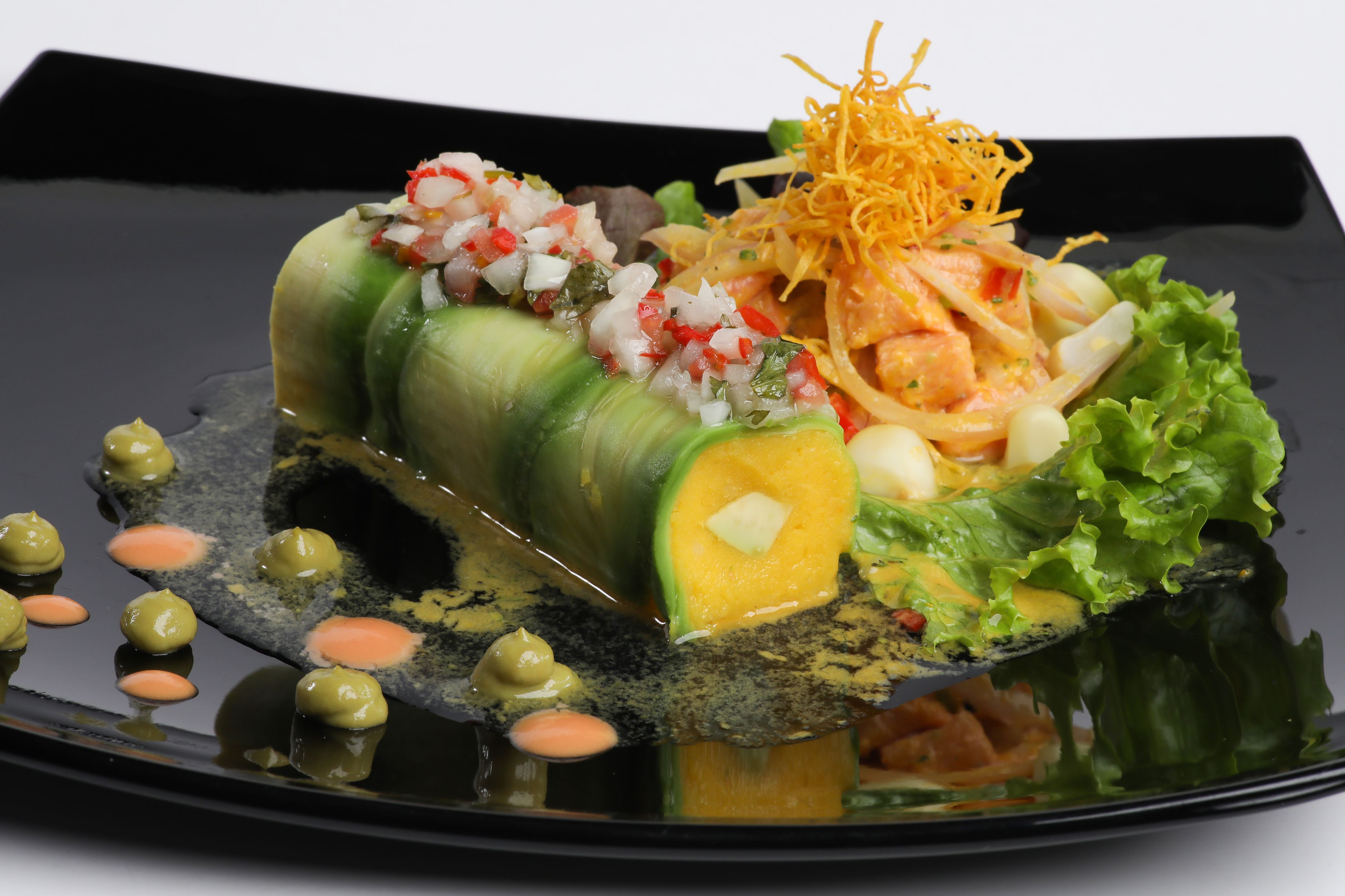 A sushi dish with various toppings and garnishes on a black plate.