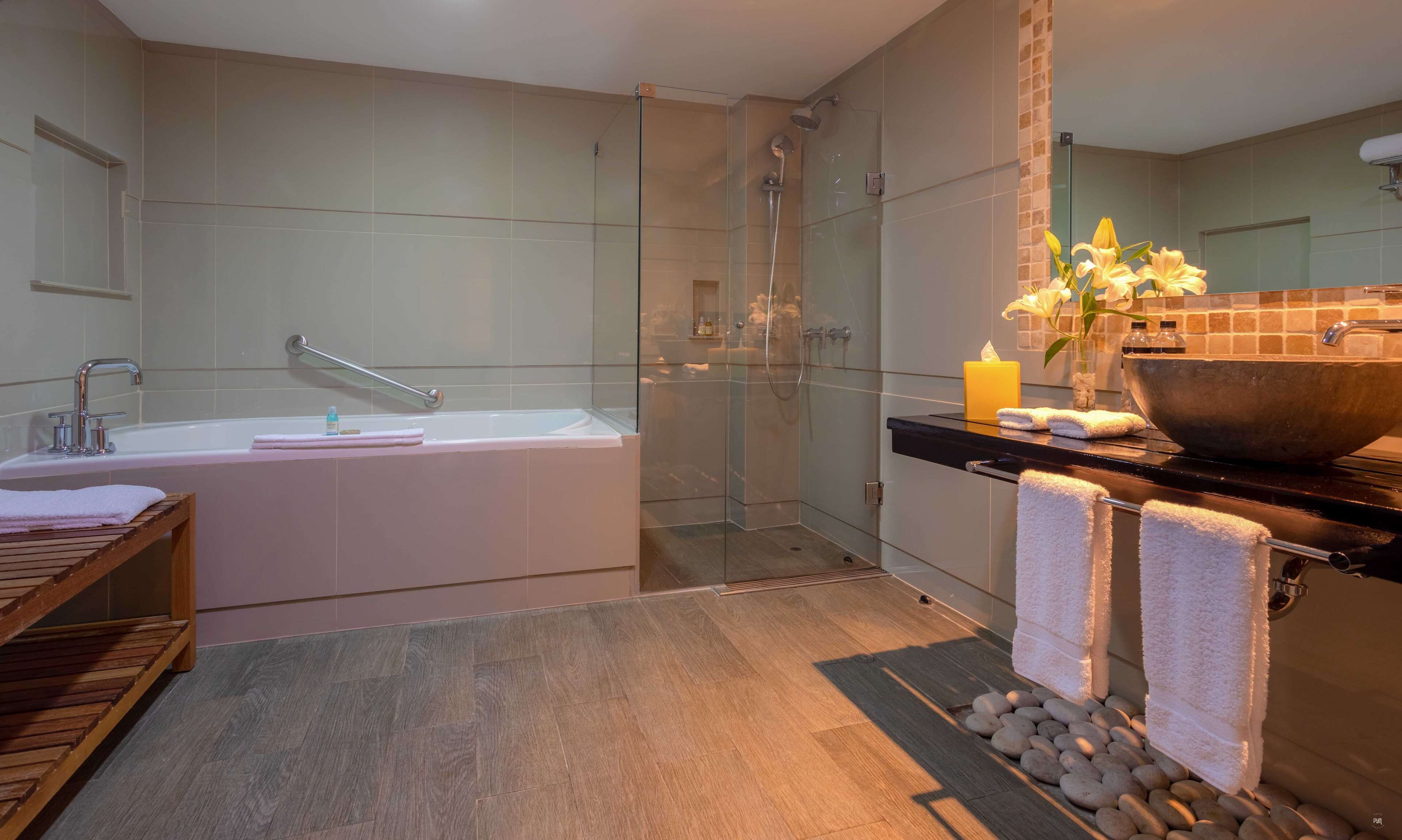 A modern bathroom with a glass-enclosed shower, a freestanding bathtub, and a vanity with a large bowl sink.
