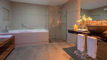 A modern bathroom with a glass-enclosed shower, a freestanding bathtub, and a vanity with a large bowl sink.